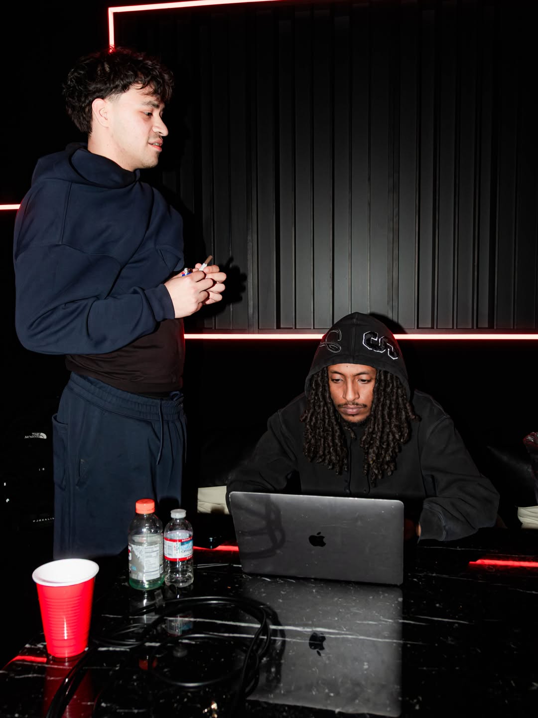 Two artists working at a laptop in a recording studio, shared by Miiir